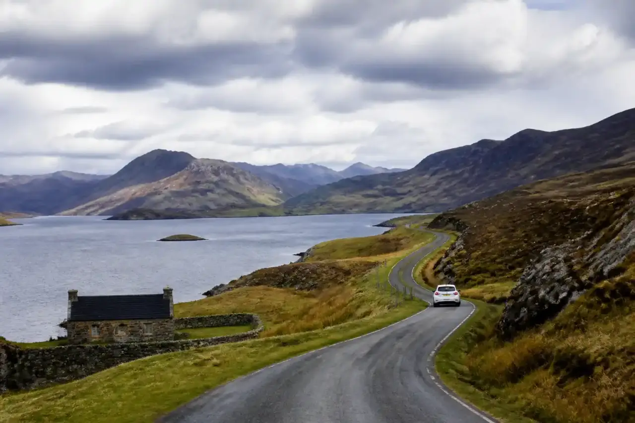 Route sinueuse dans les Highlands écossais au lever du jour